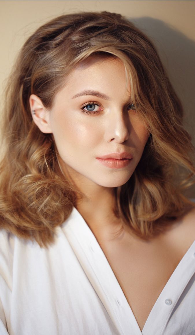 Woman with wavy hair in white shirt.