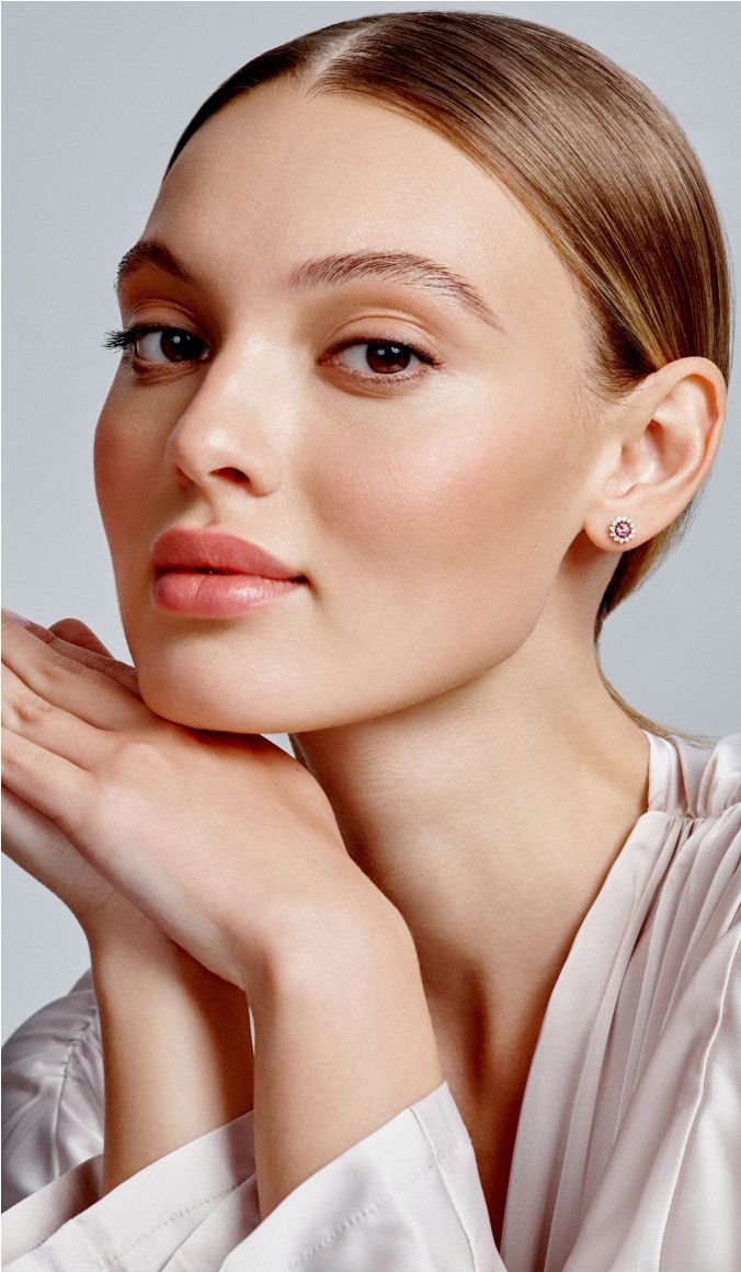 Woman with elegant earrings and soft makeup.